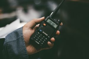 Photograph of someone holding a walkie talkie.